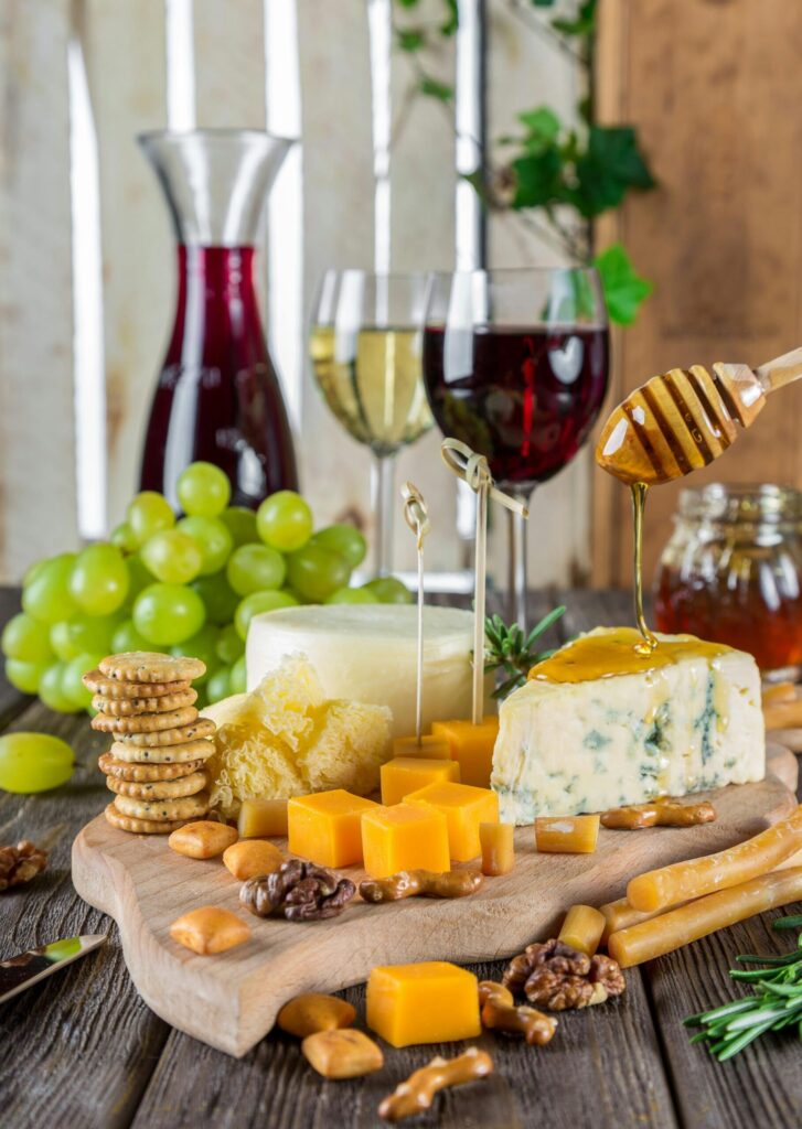 pexels-photo-248413-248413 Sophisticated cheese platter with assorted wines, grapes, honey, and nuts.